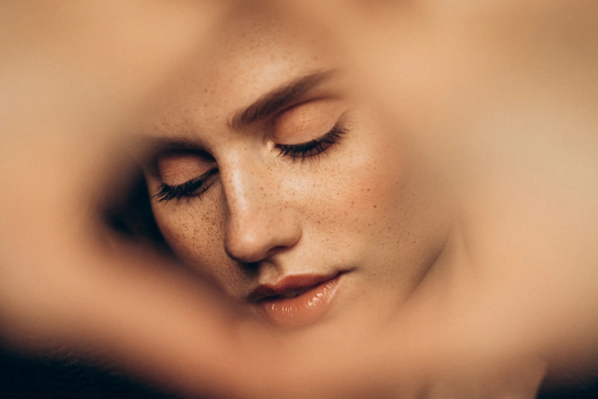 A close up of a woman's face with her eyes closed.