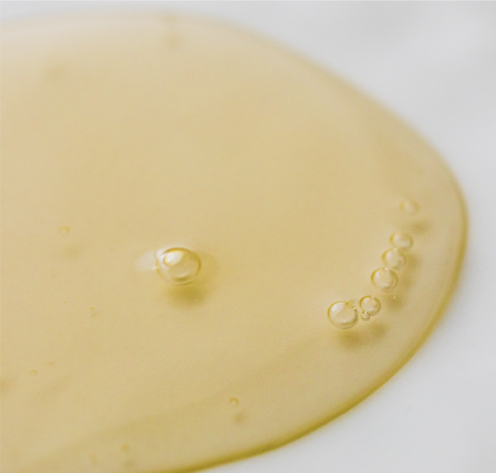 yellow tinted serum spilling on white surface