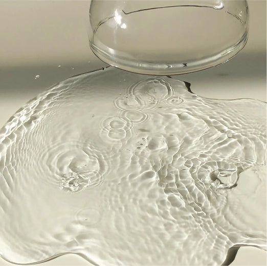 Water escaping beneath a glass jar turned upside down.