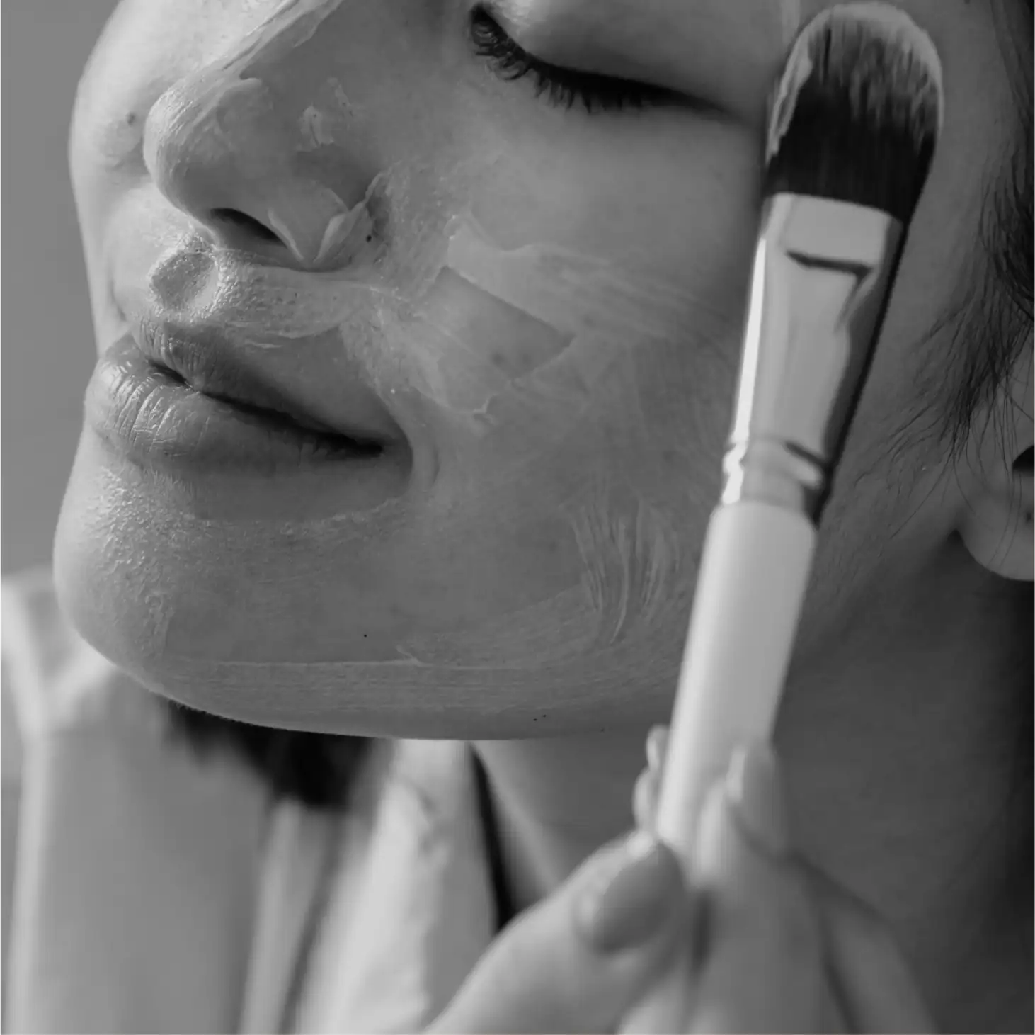 A woman holding a brush to her face.