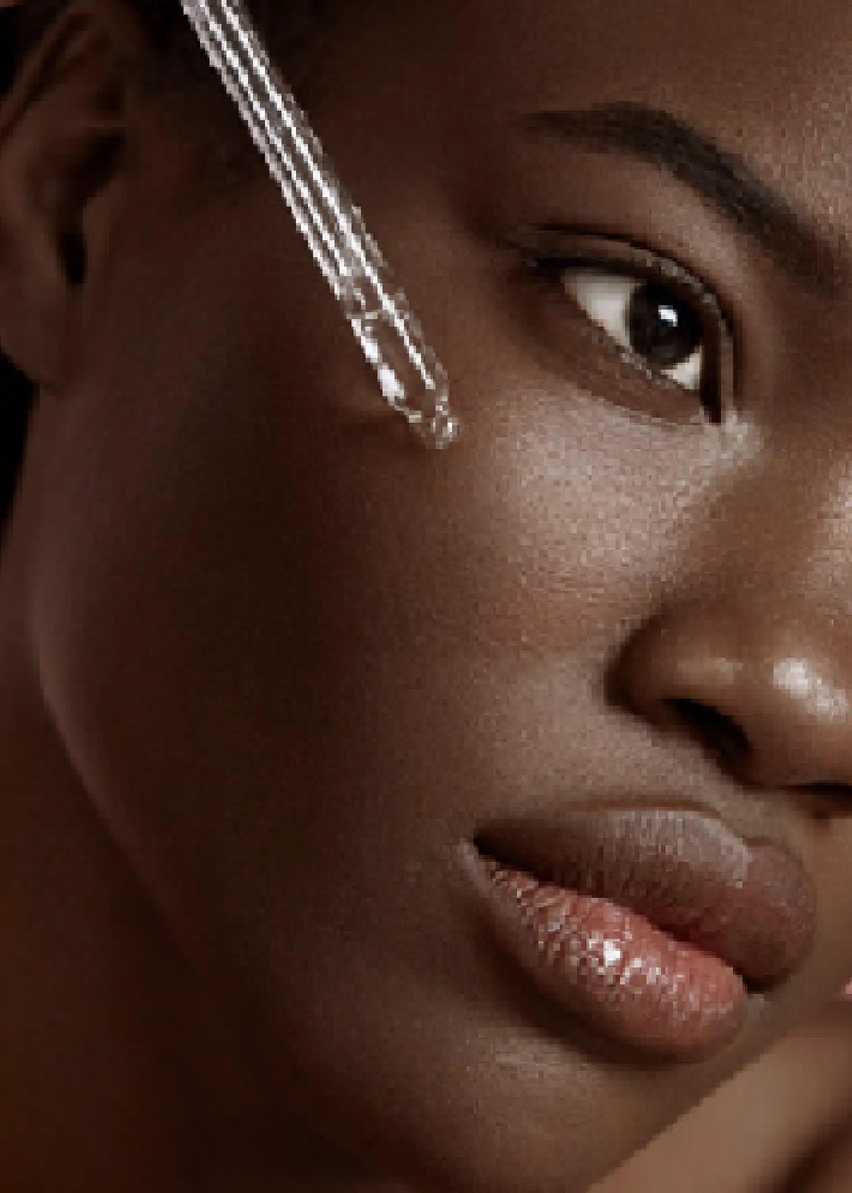A close up of a woman putting serum on her face.
